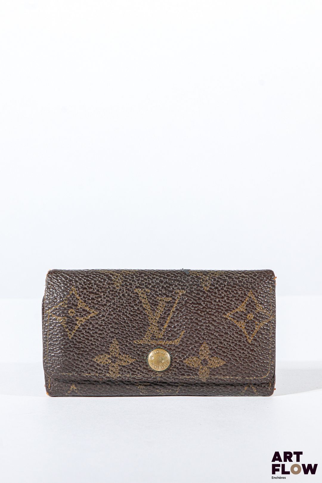 LOUIS VUITTON Porte clés en toile enduite monogrammée marron, bijouterie en métal doré, fermoir à pression sous rabat. Dimensions : 5,5 x 10 cm Usures