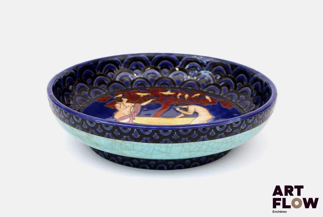 Georges BARBIER (1882-1932) Importante coupe à talon à fond bleu émaillé à décor central et polychrome de deux femmes dénudées dans un bassin. Diamètre : 26.50 cm