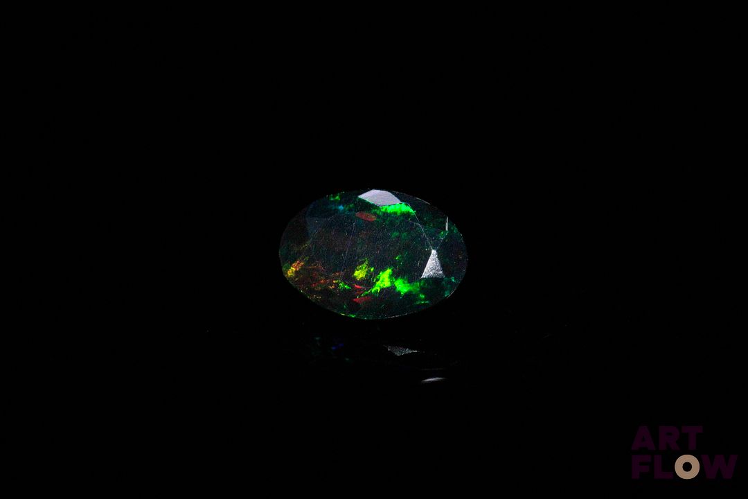 Opale facettée noire ovale. Jolie couleur. Probablement traitée. 1.57 ct. 10.6mm x 7.42mm