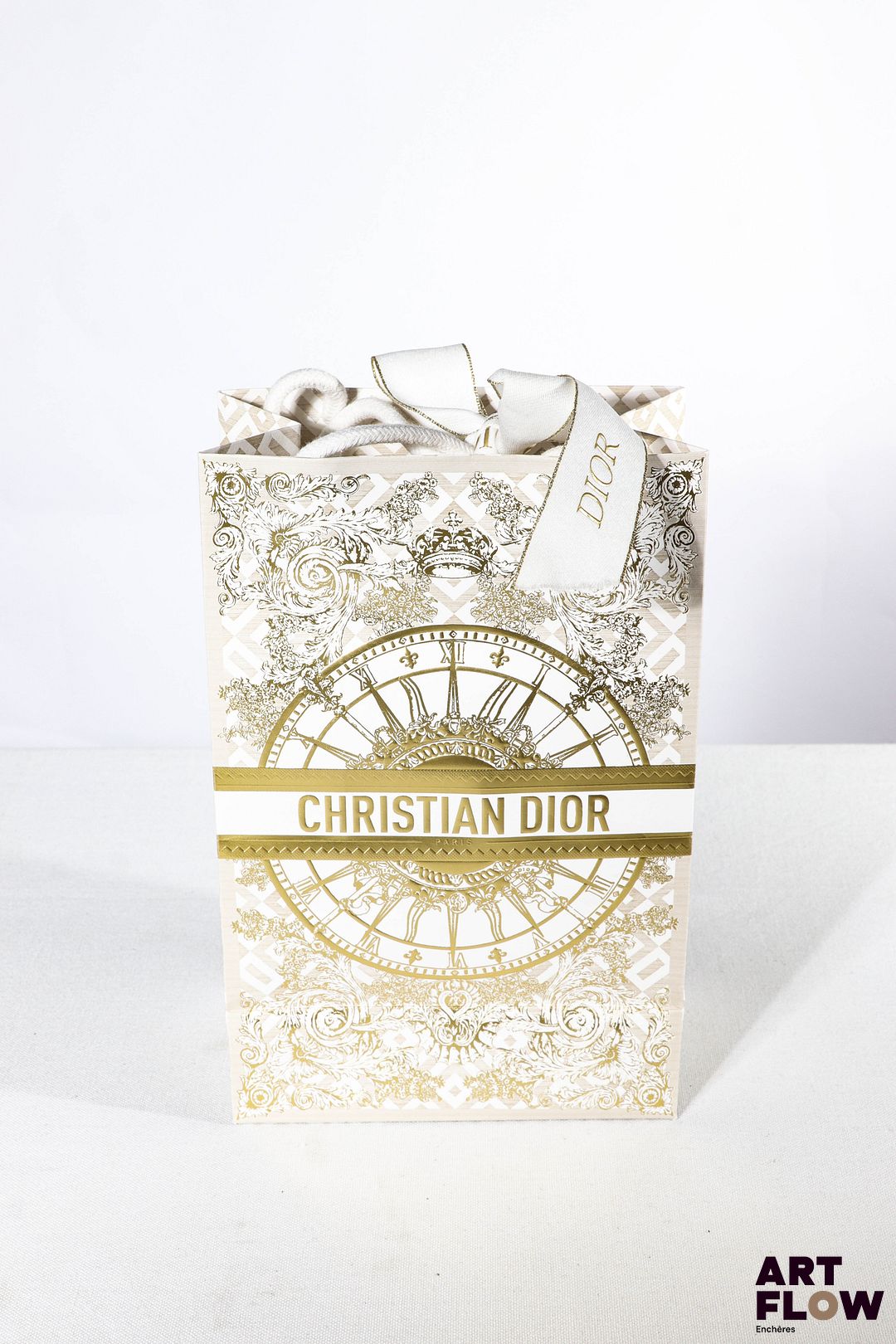 CHRISTIAN DIOR Boule à neige, l'intérieur figurant le logo CD dans un décor rayonnant, entouré de cadeaux et de sacs shopping H.14,5 cm Dans un sac Christian Dior Très bon état général