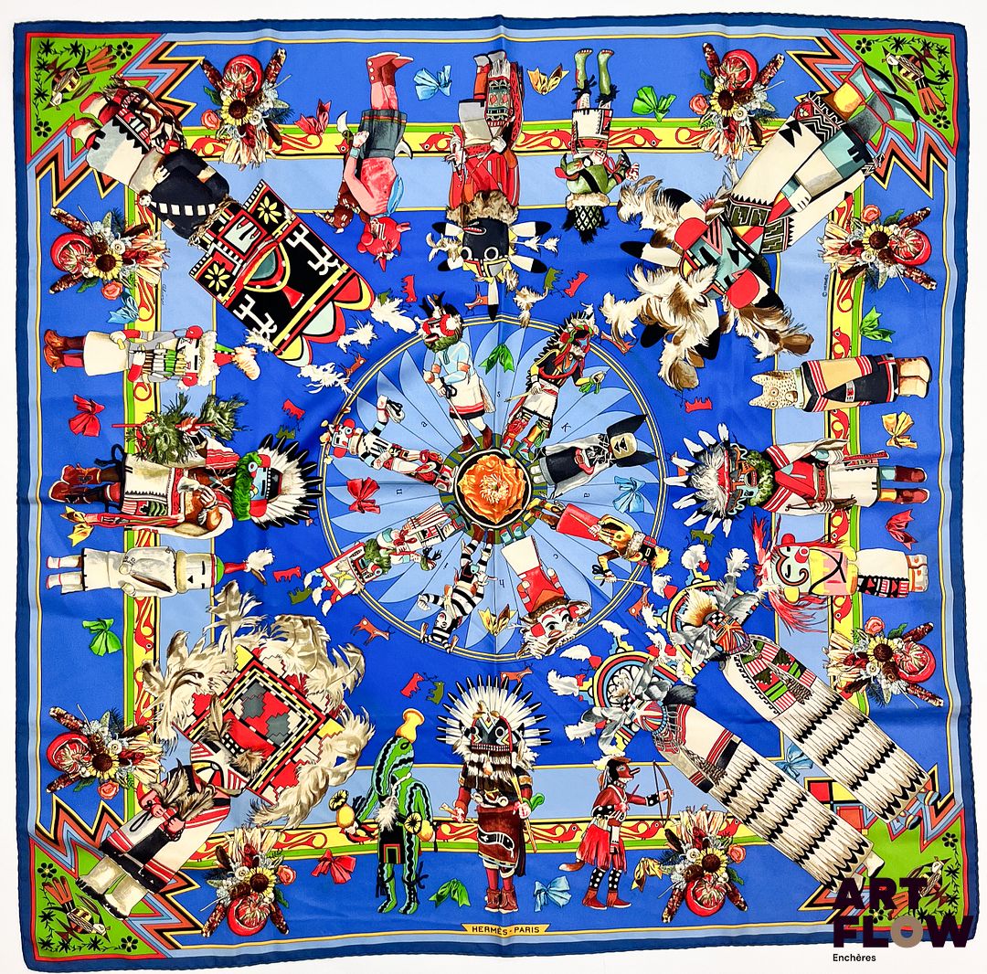 HERMÈS Modèle Kachinas d'après le dessin Olivier Kermit Carré en twill de soie dans les tons bleus Dimensions : 90 x 90 cm Micros trous et petites taches Bibliographie : Genevieve Fontan, Carrés d'art, Dictionnaire illustré des carrés Hermès valeur, 2025