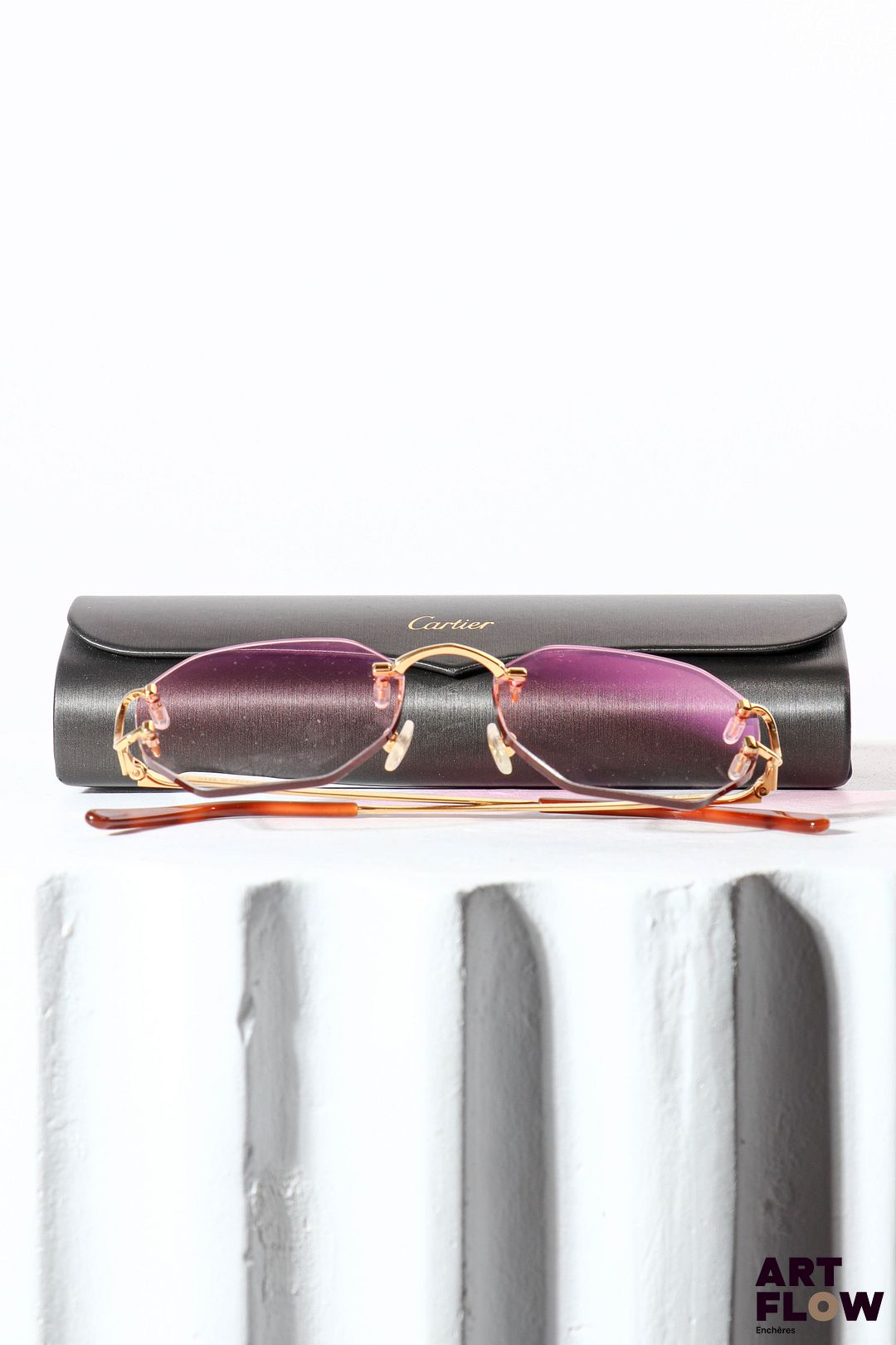 CARTIER Paire de lunettes de soleil, verres roses et branches en métal doré Dans son étui d'origine