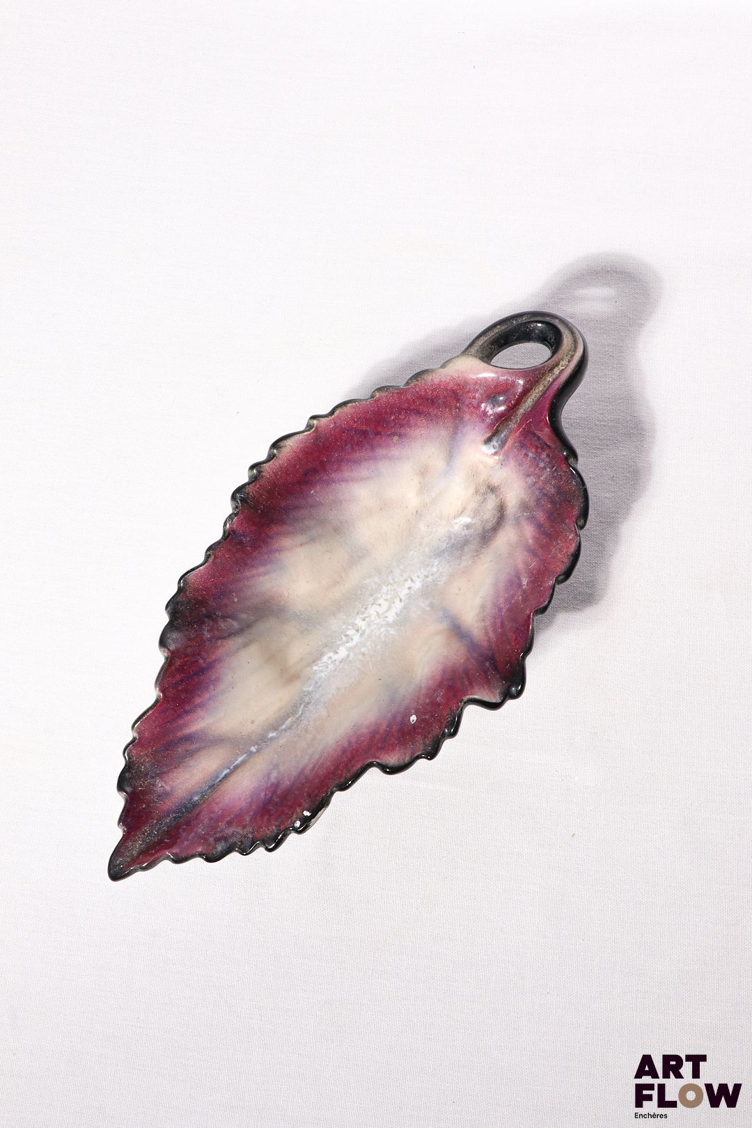 POL CHAMBOST (1906-1983) Coupe 31 "Feuille" en faience émaillée à couverte polychrome à l'intérieure, noire à l'extérieure. Incisée au revers "Made in France, PC, 31" 28 x 14 x 8 cm Bibliographie : Philippe Chambost, "Pol Chambost, Sculpteur-Céramiste 1906-1983", Somogy Editions d'Art, Paris, 2006, modèle similaire p. 76