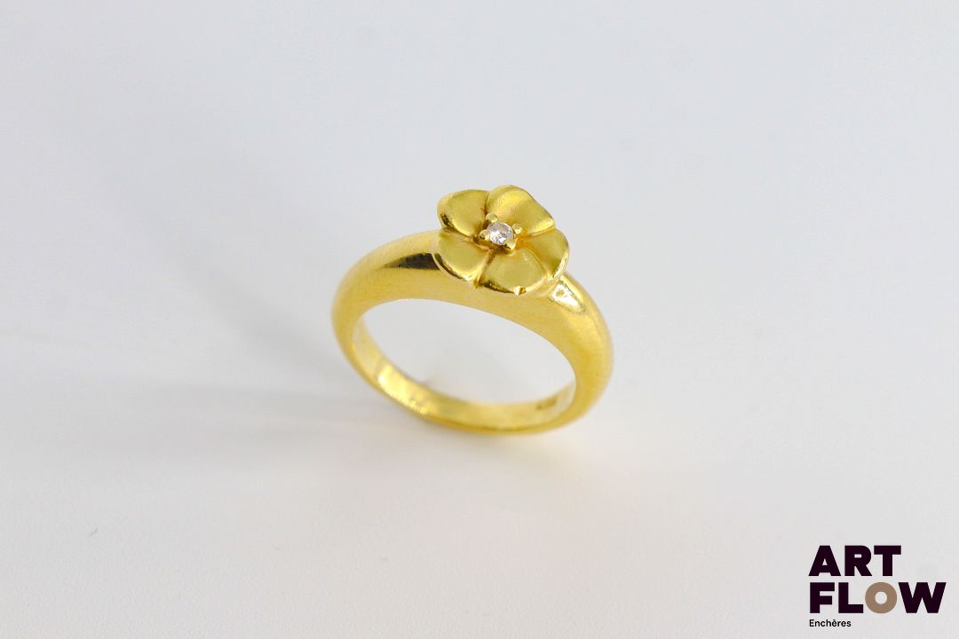 Poiray Bague en or jaune 750/°°, ornée d'une fleur centrée d'un petit diamant figurant son pistil. Très bon état général malgré quelques petites rayures d'usage. Poids brut : 6.39 gr TDD 48
