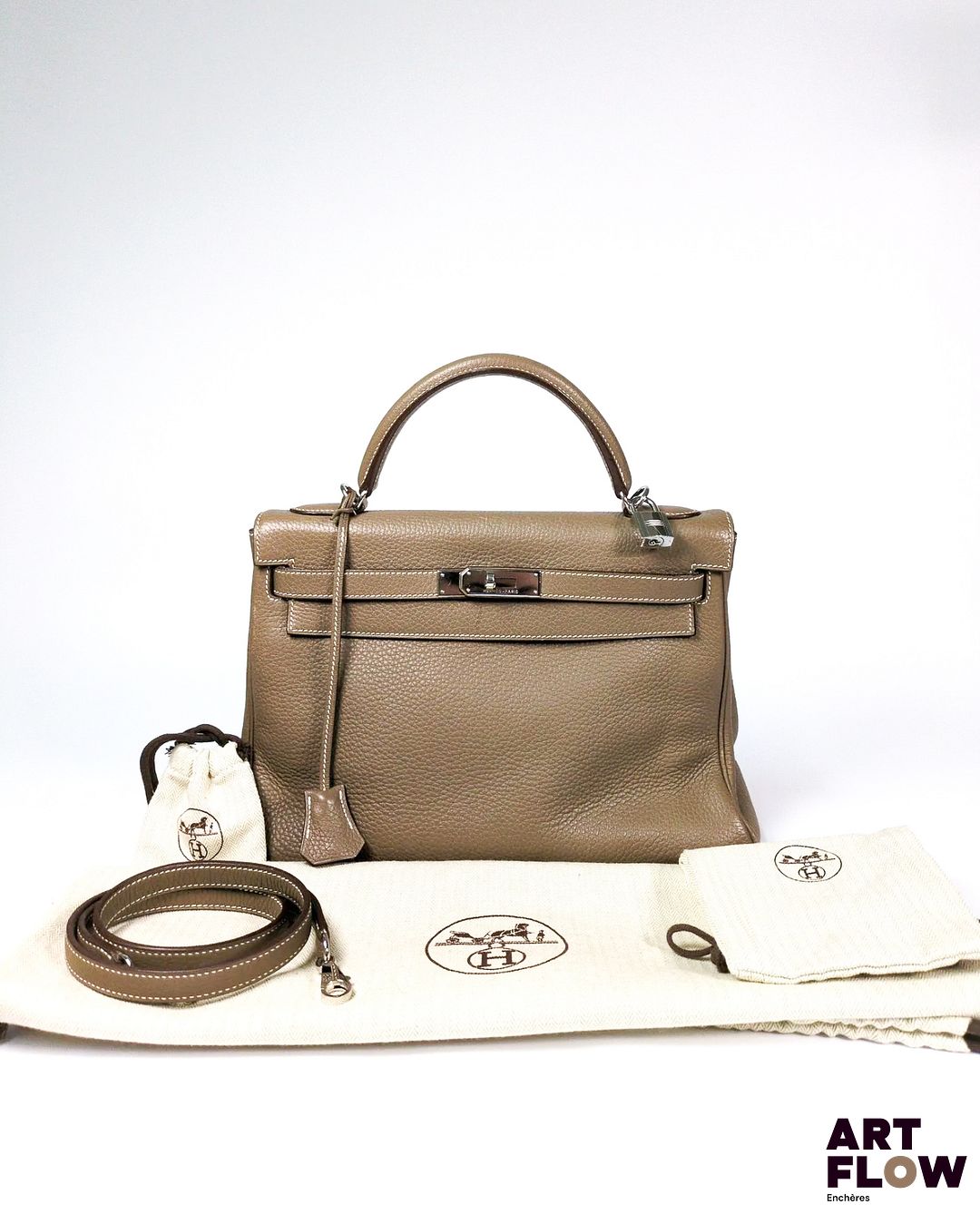 HERMÈS Kelly II Sac Kelly retourné 32 en cuir Taurillon Clémence étoupe, garniture en métal argenté Lettre K dans un carré : année 2007 Avec ses clés, clochette, cadenas, et bandoulière. Dimensions : 32 x 23 x 10,5 cm Facture incluse. Dans son pochon, sa boîte et son sac d'origine. Quelques marques d'usures, dont petites griffures et taches (voir photos).