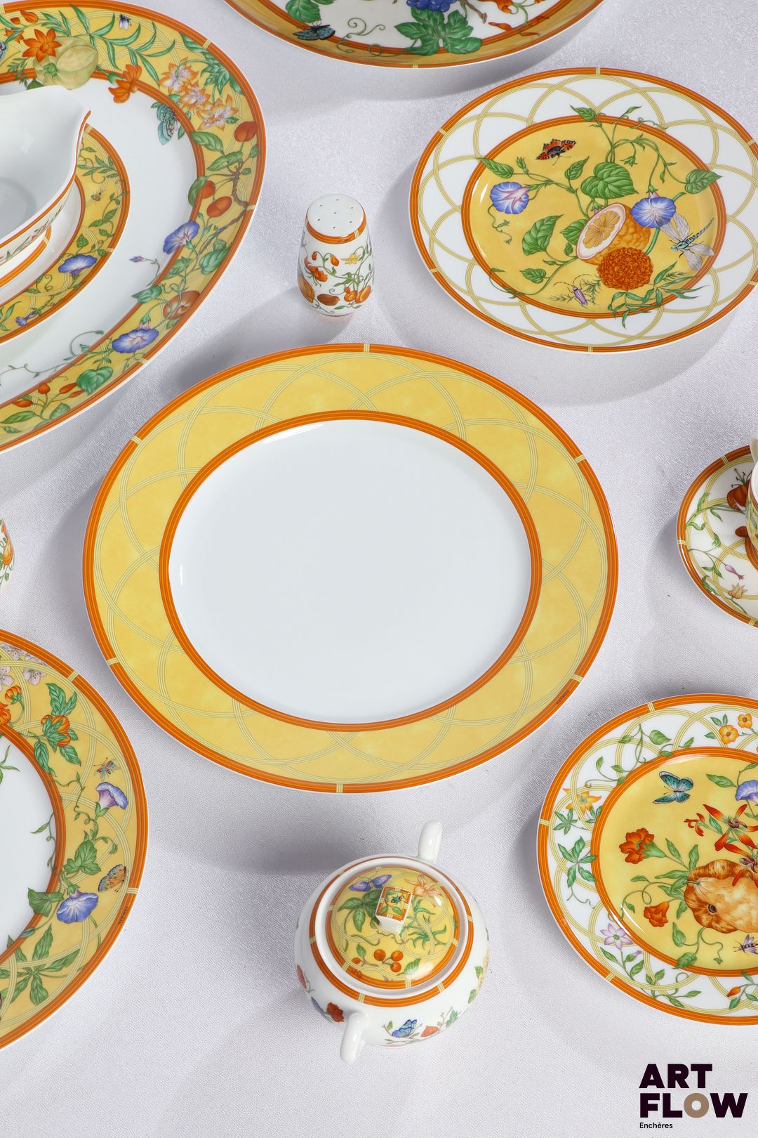 HERMÈS "La siesta D'Hermès" Rare partie de service en porcelaine à décor polychrome, particulièrement complet, de 95 pièces comprenant : - Douze assiettes de présentation (D. 30 cm) - Vingt-quatre assiettes à dîner (D. 27,5 cm) - Douze assiettes à dessert à décor de coings (D. 19 cm) - Douze assiettes à dessert à décor de citrons (D. 22,5 cm) - Douze tasses et sous tasses (D. 13 cm) - Deux plats creux (D. 29,5) - Un grand plat (D. 31,5 cm) - Un grand plat ovale (41 x 30 cm) - Un petit plat ovale (21 x 16 cm) - Deux saladiers (D. 24,5 cm) - Une saucière (L. 19 cm) - Un sucrier (H. 10 cm) - Un poivrier et salière Dans leur boîte d'origine.