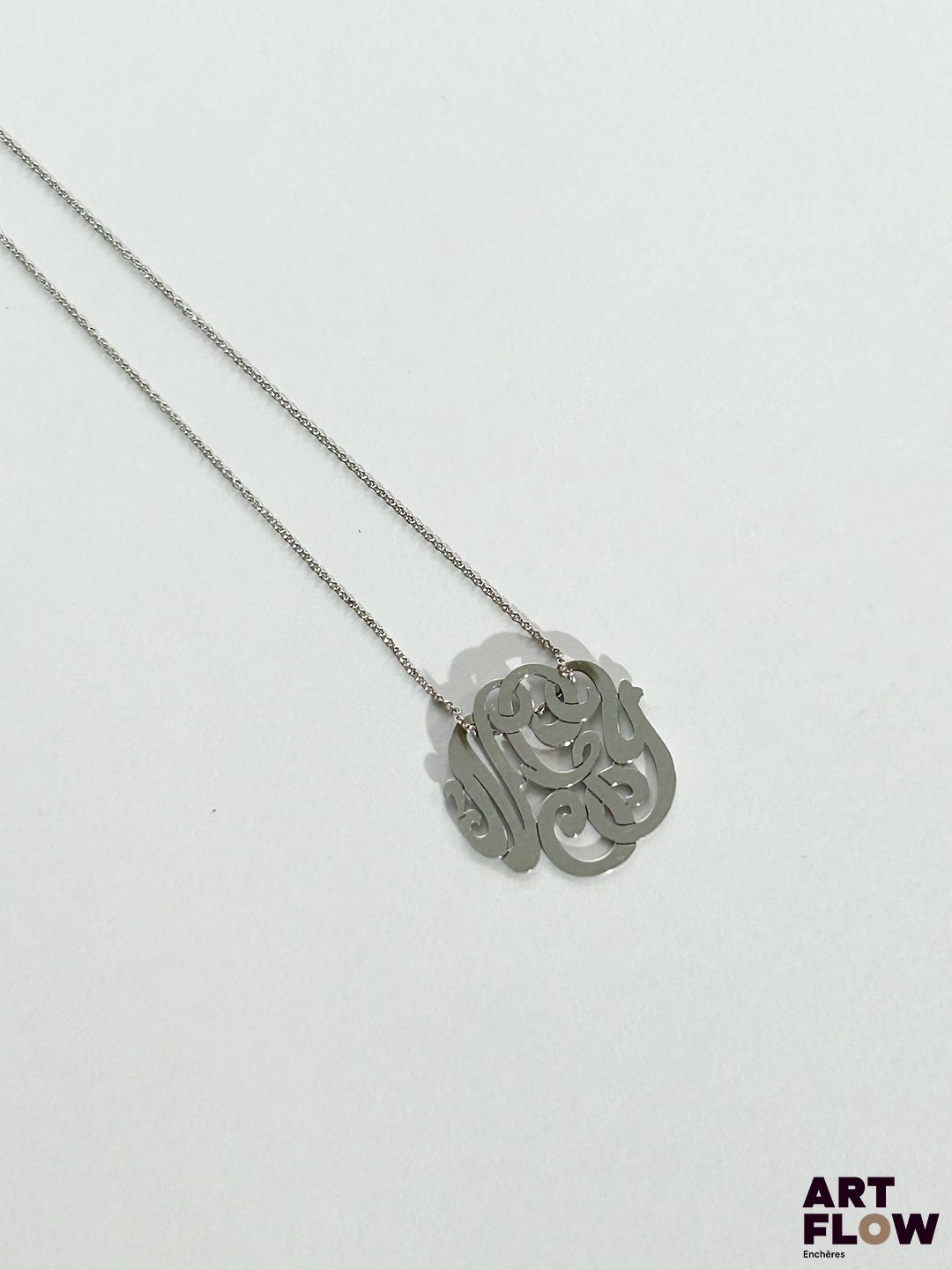 GINETTE NEW YORK Collier sur chaine et pendentif monogramme en or 18k (750/1000) Signé Pendentif : 17 mm environ Poids brut : 2,19 g Dans son pochon