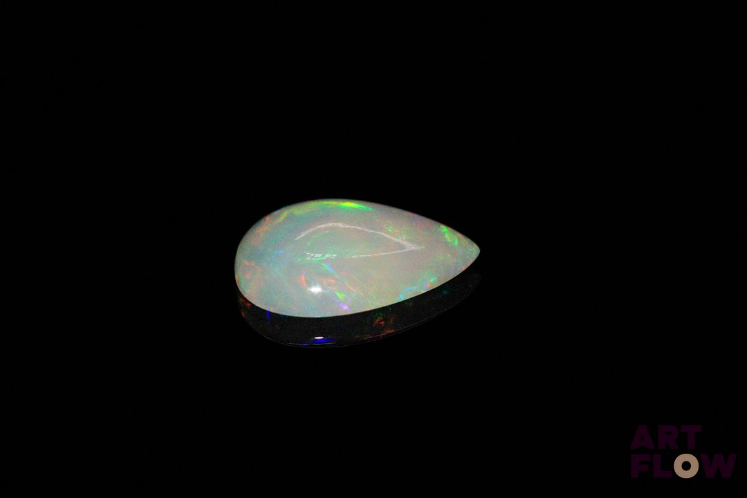 Opale blanche cabochon poire. Très beaux éclats de couleur, dominante rouge. 1.78 ct. 13.0mm x 9.0mm