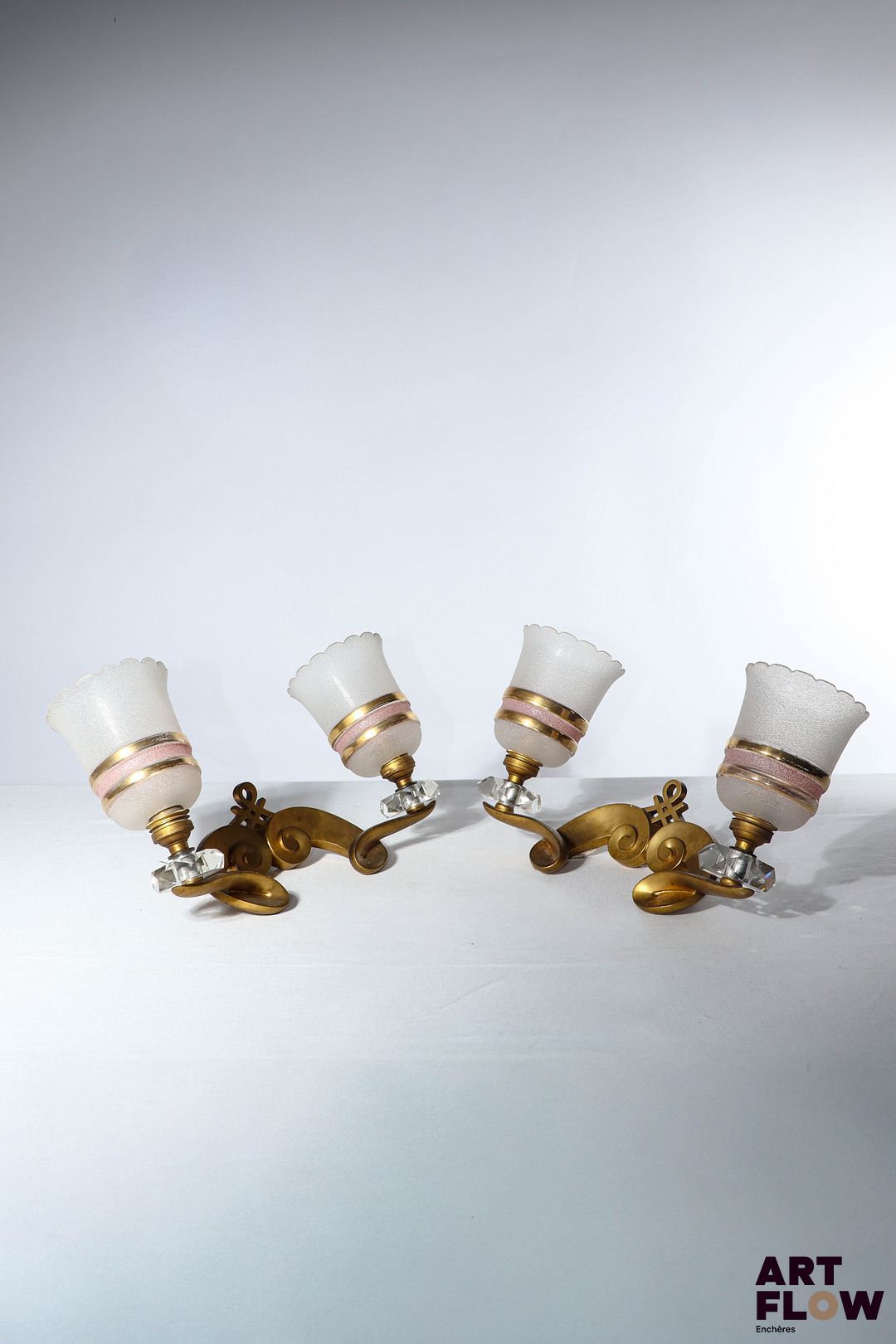 Attribué à Jules LELEU (1883-1961) Paire d'appliques murales en laiton doré et verre. L. 32 cm environ Bon état général malgré quelques légers défauts (ébrechures sur le verre et frottement au dos des appliques. Fonctionnement électrique non garanti)